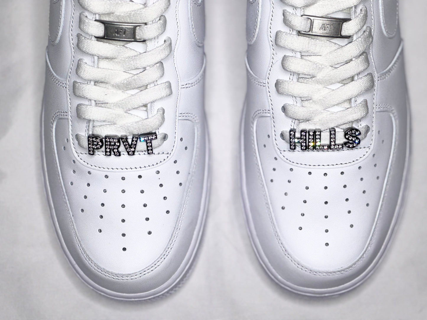 Air Force 1 x Private HillsMetal Lace Tips 
BLACK PRIVATE HILLS BRANDING ON SIDES
PRVT HILLS RHINESTONE CHARMS ON BOTTOM LACESSneakersPrivate Hills