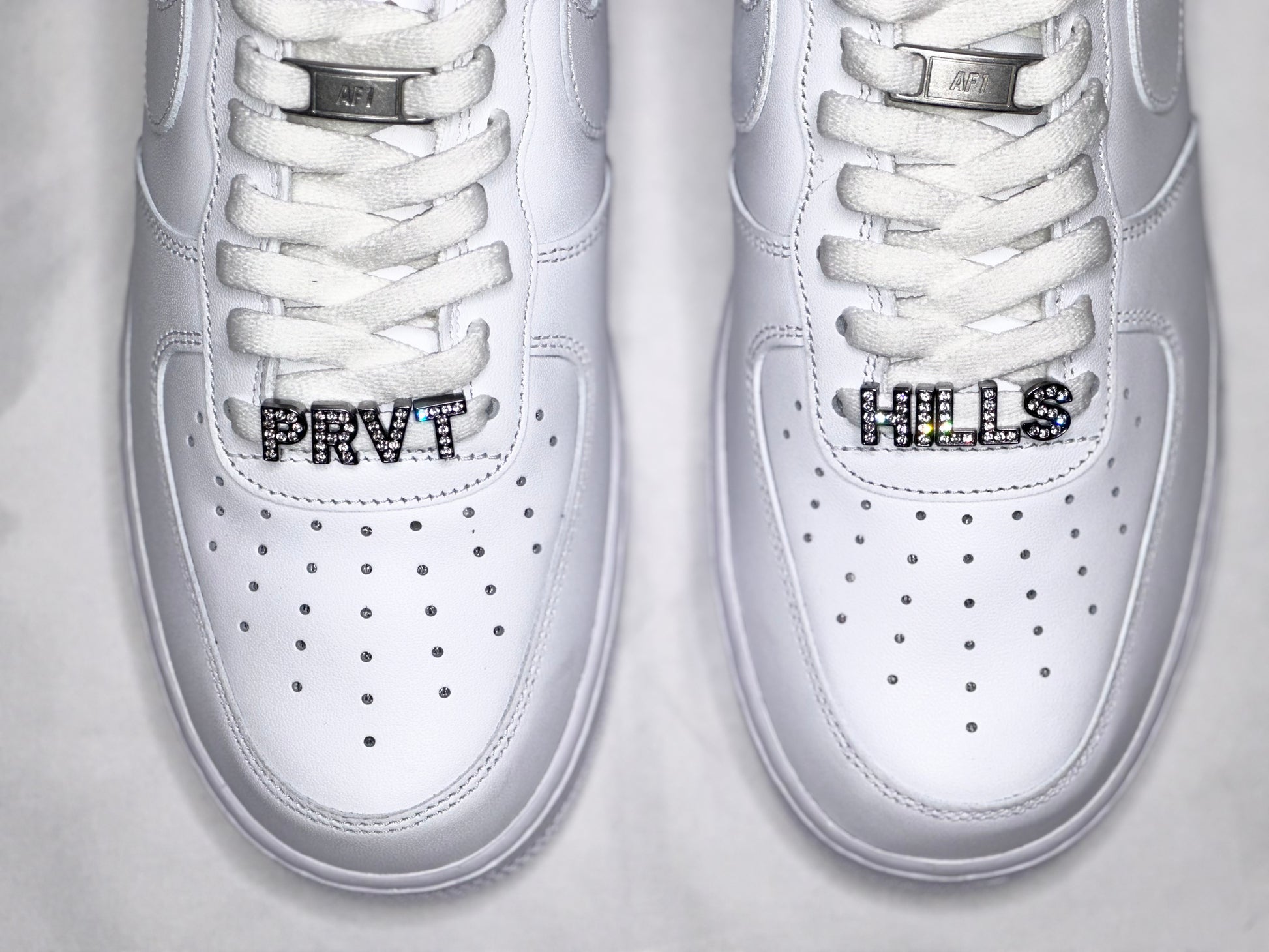 Air Force 1 x Private HillsMetal Lace Tips 
BLACK PRIVATE HILLS BRANDING ON SIDES
PRVT HILLS RHINESTONE CHARMS ON BOTTOM LACESSneakersPrivate Hills